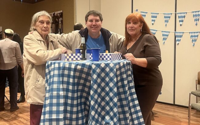 a man and two women standing around a table