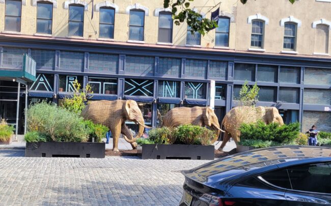 Three elephant sculptures, part of the “The Great Migration” exhibit, in front of a Meatpacking District building.